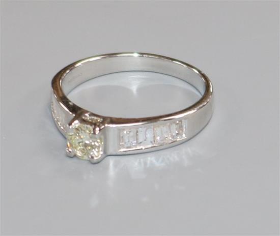 A modern 18ct white gold and single stone diamond ring, with baguette cut diamond set shoulders, size M.